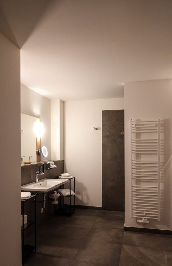 A sleek and modern bathroom design featuring minimalist aesthetics with warm lighting and stylish fixtures.